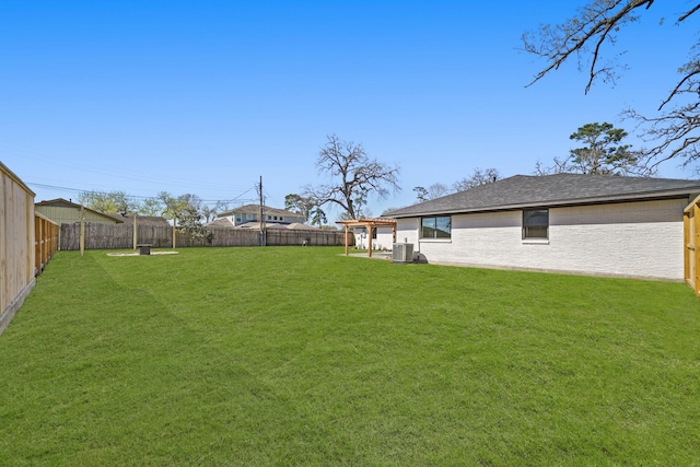 view of yard with central AC and a fenced backyard