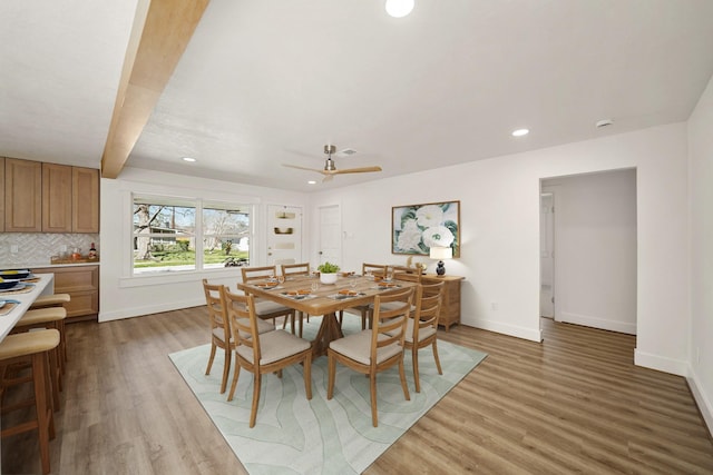 dining room with recessed lighting, beamed ceiling, baseboards, and wood finished floors