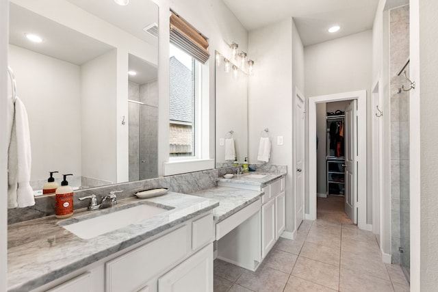 bathroom featuring a wealth of natural light, tile patterned flooring, a shower stall, and a walk in closet