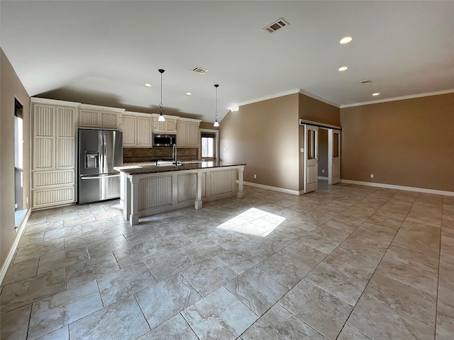 kitchen featuring visible vents, a center island with sink, appliances with stainless steel finishes, cream cabinetry, and a sink