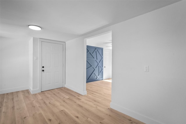 empty room with baseboards and light wood finished floors