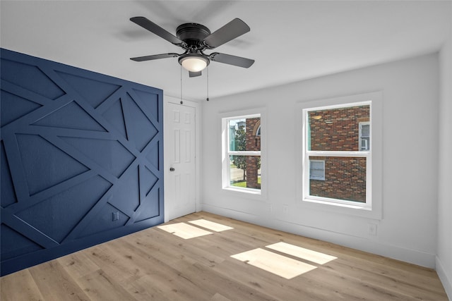 spare room with a ceiling fan, baseboards, and wood finished floors