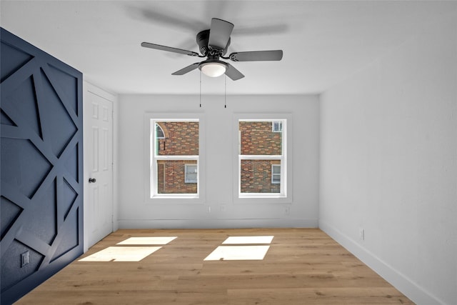 empty room featuring baseboards, light wood-style floors, and a ceiling fan