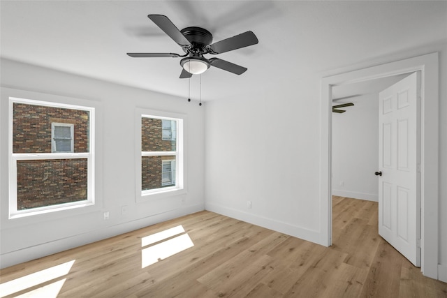 empty room with baseboards, light wood-style floors, and a ceiling fan