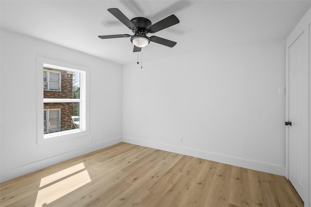 empty room with ceiling fan, light wood-type flooring, and baseboards