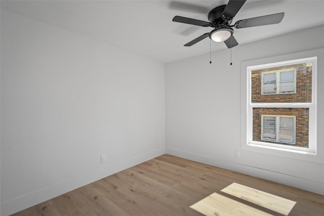 empty room with a ceiling fan, baseboards, and wood finished floors