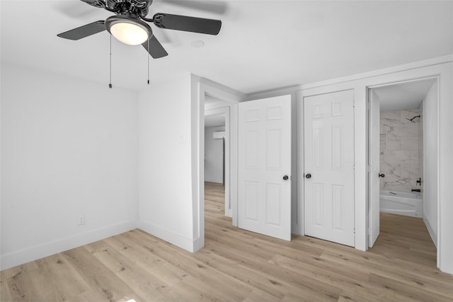 unfurnished bedroom featuring a closet, ceiling fan, light wood-type flooring, and baseboards