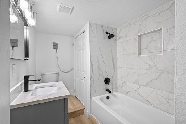 full bath featuring vanity,  shower combination, wood finished floors, and visible vents