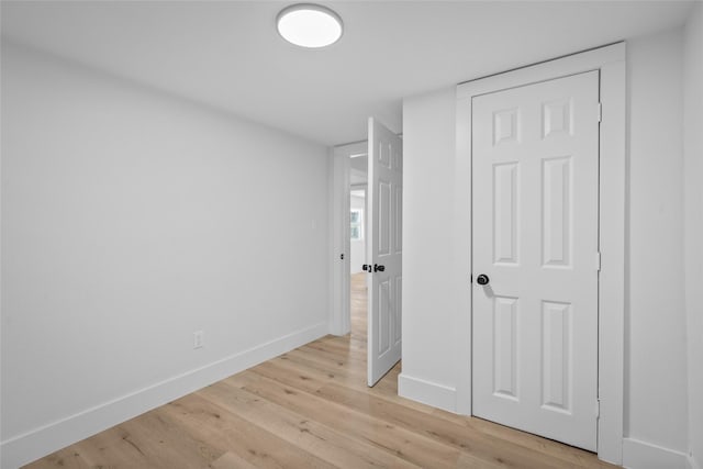 unfurnished bedroom featuring light wood-type flooring and baseboards