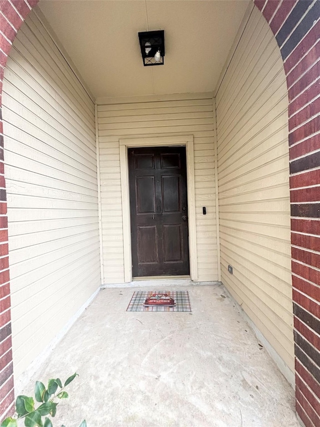 entrance to property featuring brick siding