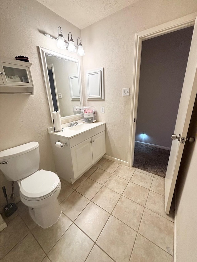 bathroom featuring vanity, tile patterned flooring, a textured ceiling, toilet, and a textured wall