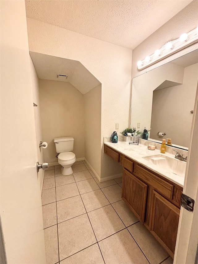 bathroom featuring vanity, visible vents, a textured ceiling, tile patterned floors, and toilet