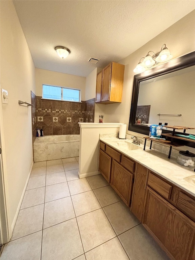 full bathroom with visible vents, double vanity, tile patterned floors, a textured ceiling, and a sink