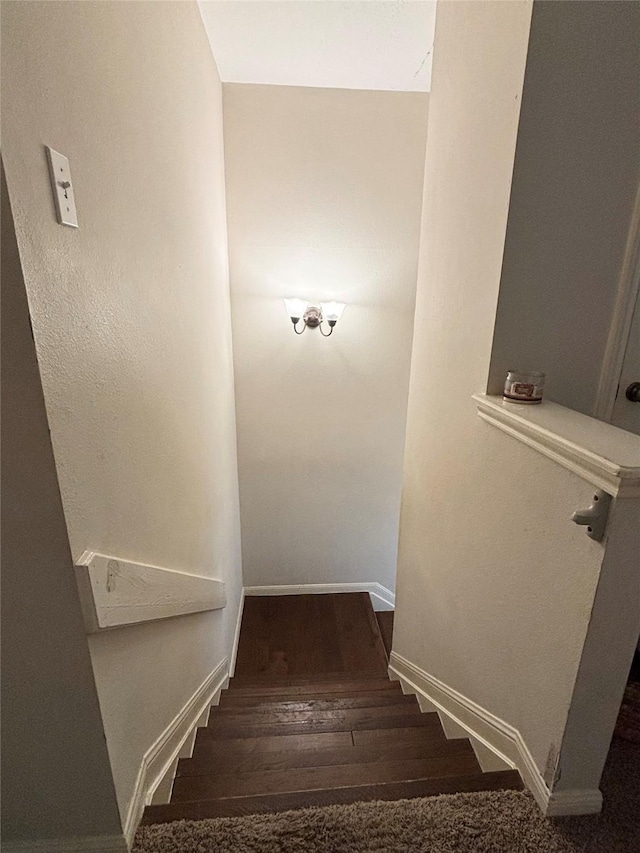 stairway featuring baseboards and wood finished floors