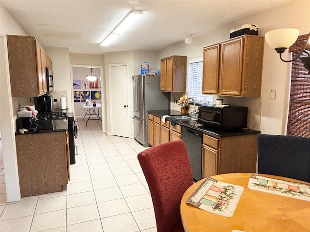 kitchen with black appliances, light tile patterned flooring, dark countertops, and brown cabinets