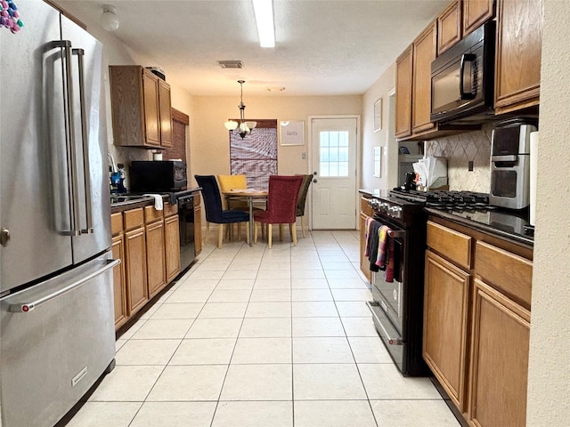 kitchen with dark countertops, visible vents, light tile patterned floors, decorative backsplash, and black appliances