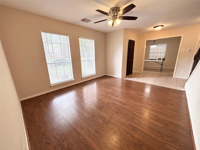 spare room featuring visible vents, baseboards, light wood-style floors, and ceiling fan