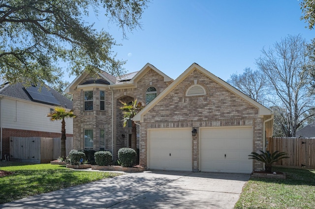 traditional-style home featuring brick siding, a garage, concrete driveway, and fence