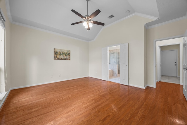 unfurnished bedroom featuring visible vents, wood finished floors, lofted ceiling, and ornamental molding