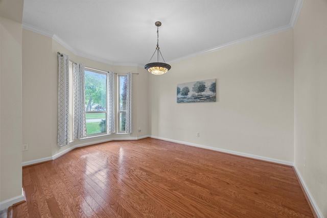 unfurnished room featuring baseboards, ornamental molding, and wood finished floors