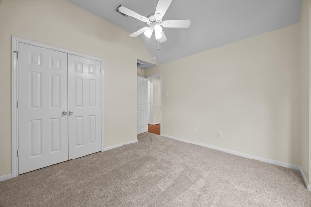 unfurnished bedroom featuring vaulted ceiling, carpet, baseboards, a ceiling fan, and a closet