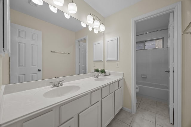 bathroom with double vanity, toilet, tile patterned flooring, and a sink