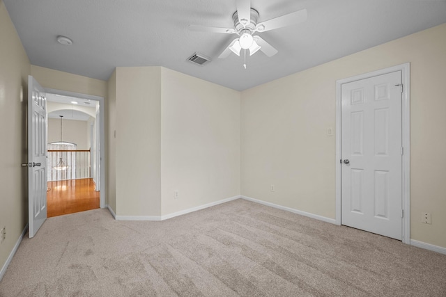 unfurnished bedroom featuring baseboards, visible vents, carpet floors, and a ceiling fan