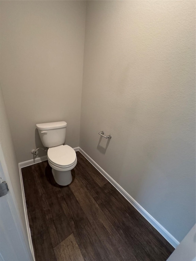 bathroom featuring toilet, baseboards, and wood finished floors