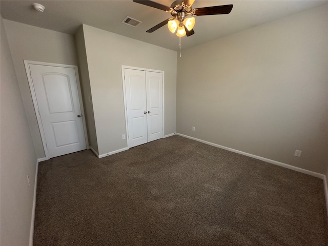 unfurnished bedroom with baseboards, visible vents, ceiling fan, a closet, and dark carpet