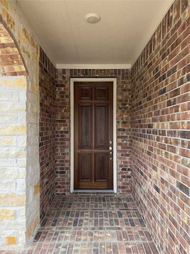 entrance to property featuring brick siding