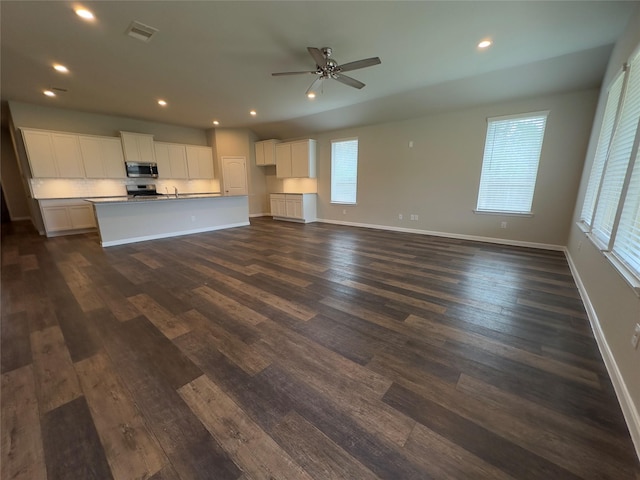 unfurnished living room featuring visible vents, recessed lighting, baseboards, and dark wood-style flooring