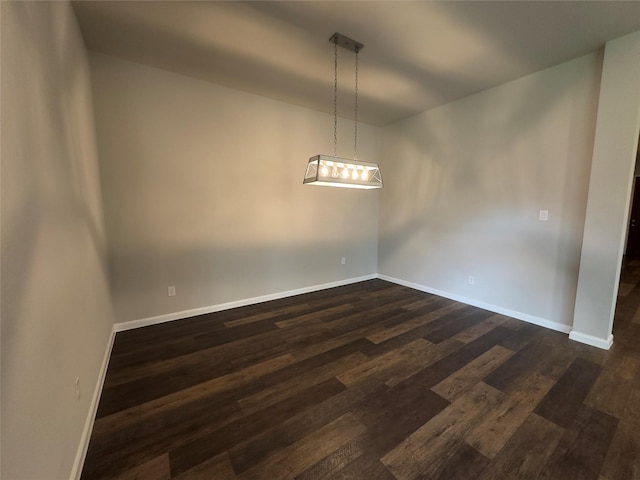 empty room featuring baseboards and dark wood-style flooring