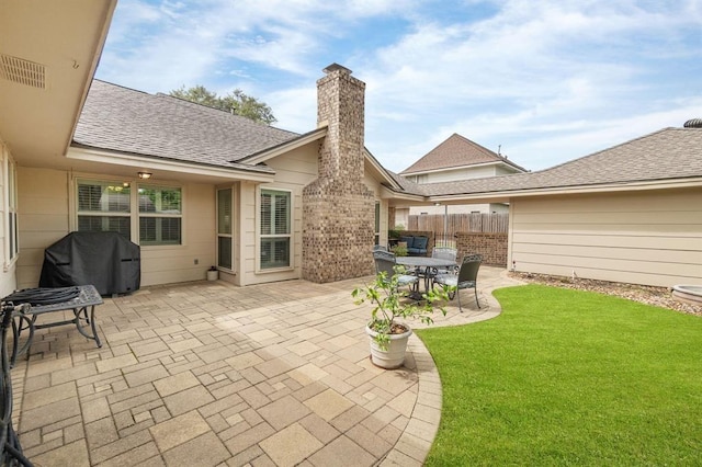 view of patio with area for grilling and fence