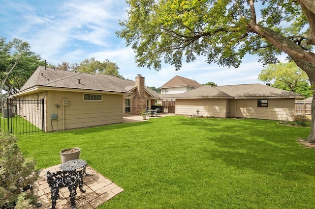 rear view of property with a yard, fence, and a patio area