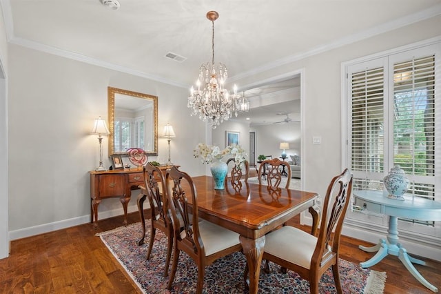 dining space featuring visible vents, crown molding, baseboards, and wood finished floors