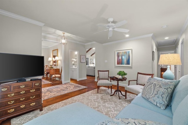 living area with ornamental molding, a ceiling fan, baseboards, and wood finished floors