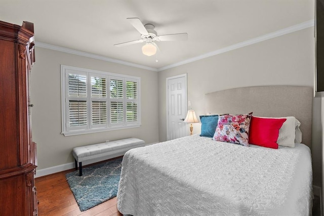 bedroom with baseboards, a ceiling fan, wood finished floors, and crown molding