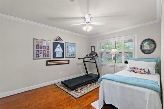 bedroom with a ceiling fan, crown molding, baseboards, and wood finished floors