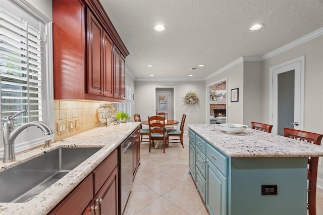 kitchen with dishwasher, a brick fireplace, ornamental molding, and a sink