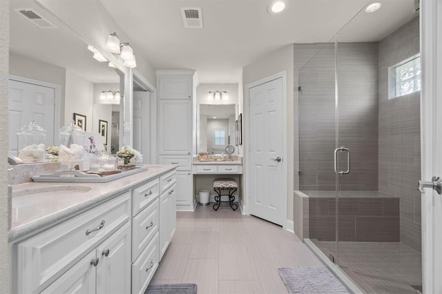 bathroom featuring visible vents, vanity, and a shower stall