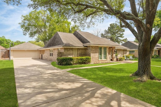 view of front of house featuring a front lawn, fence, brick siding, and roof with shingles