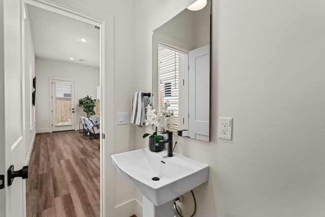 hall with a sink, baseboards, and wood finished floors