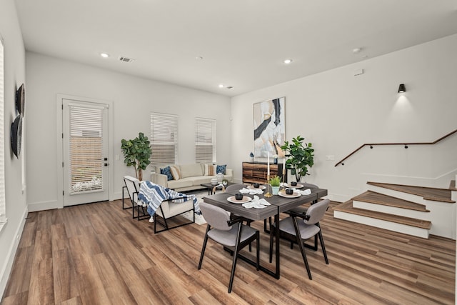 dining space with visible vents, baseboards, stairs, recessed lighting, and wood finished floors