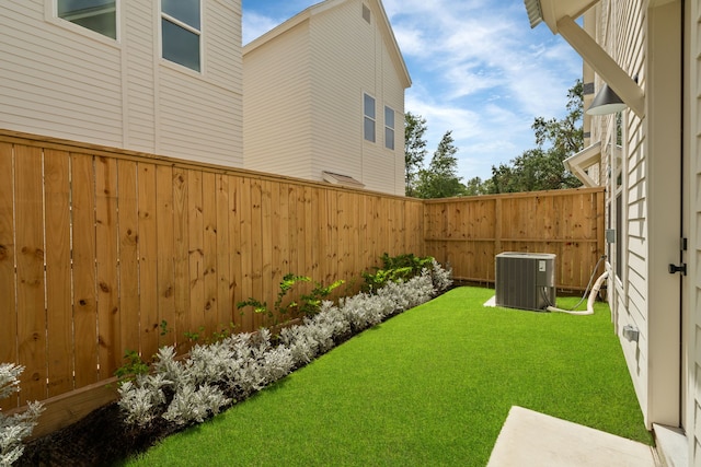 view of yard featuring central air condition unit and fence