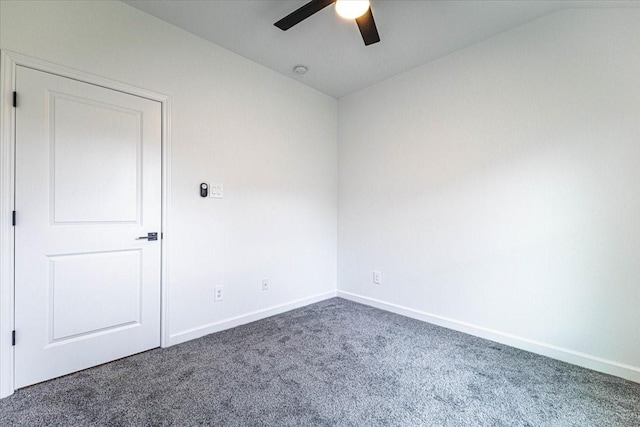 carpeted spare room featuring vaulted ceiling, a ceiling fan, and baseboards