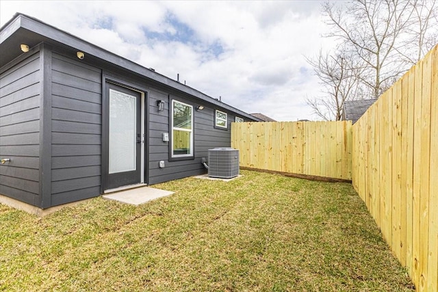 back of house with fence, central AC unit, and a lawn