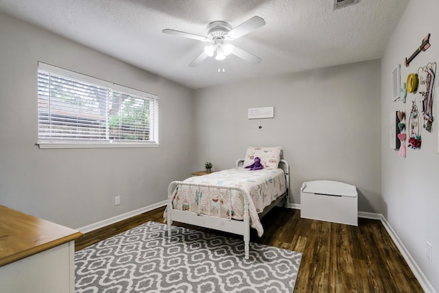 bedroom featuring baseboards, a textured ceiling, wood finished floors, and a ceiling fan