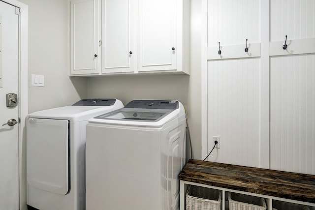 laundry room featuring washing machine and clothes dryer and cabinet space