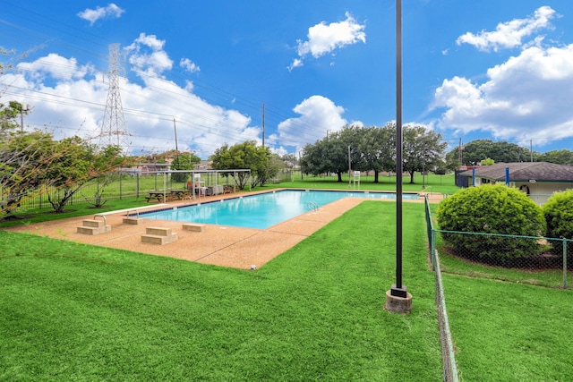 view of swimming pool featuring a lawn and fence