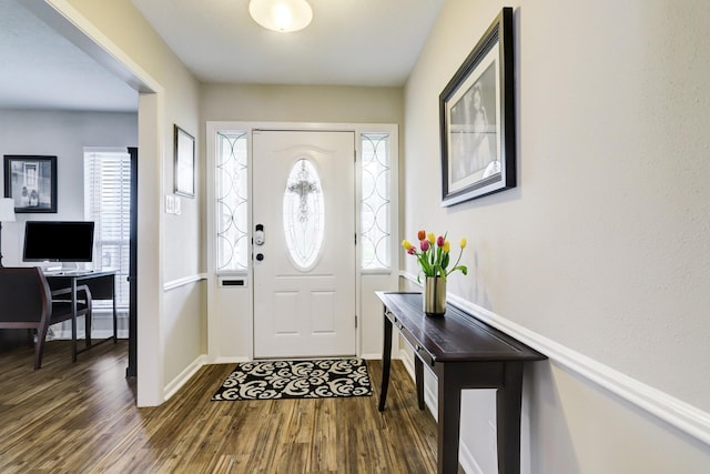 foyer entrance featuring baseboards and dark wood-type flooring